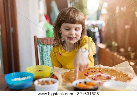 Little girl decorating mazurek (Polish Easter cake)