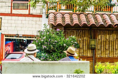 People Of Colombia, Group Of Old Man Sitting On Bench In The Colorful Streets Of Filandia Village