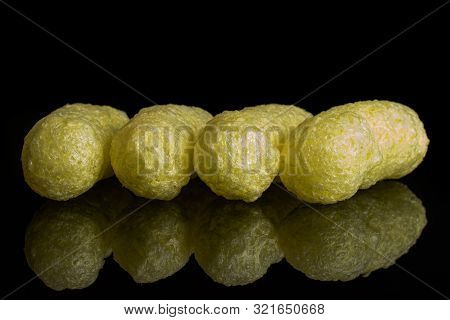 Group Of Four Whole Salted Yellow Corn Puff Isolated On Black Glass