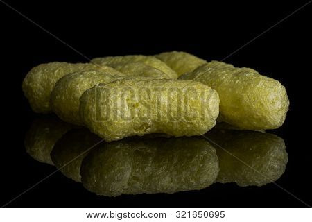 Group Of Six Whole Salted Yellow Corn Puff Isolated On Black Glass