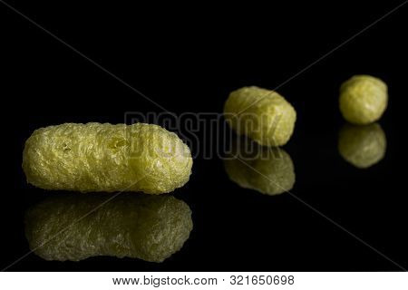 Group Of Three Whole Salted Yellow Corn Puff Isolated On Black Glass