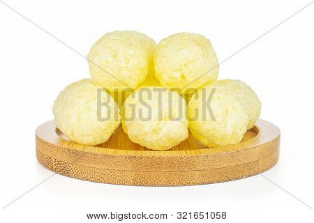 Group Of Five Whole Salted Yellow Corn Puff On Bamboo Coaster Isolated On White Background