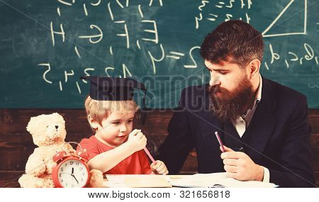 Hometask Concept. Father Checking Hometask, Helps To Boy, Son. Enthusiastic Kid Studying With Teache