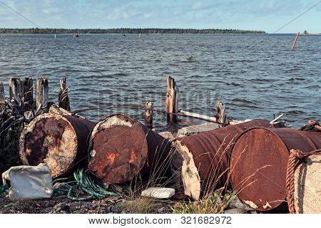 Old Barrels Have Been Left To Rot By The Remains Of An Old Wooden Pier At The Fishing Harbour Of Kal