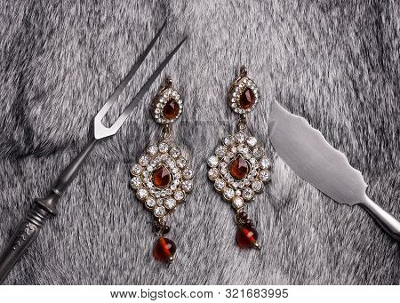 Earrings Made Of Precious Stones Lying On Gray Fur. Conceptual Shot. Food Made From Jewelry. Beautif