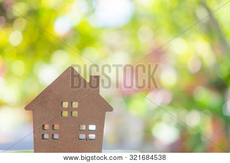 Closed Up Tiny Home Model On Floor Or Wood Board With Sunlight Green Bokeh Background. Deam Life Hav