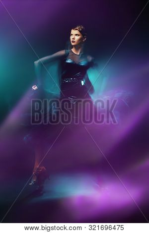 Beautiful girl performs Latino dance with expression. Professional dancer in motion. Beauty, fashion.