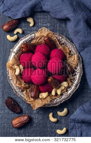 Energy balls with medjool dates, nuts and raspberry powder