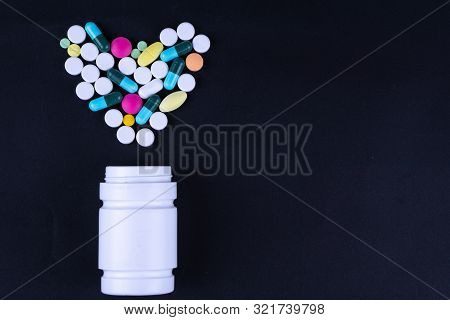 Assorted Pharmaceutical Medicine Pills, Tablets And Capsules And Bottle On Black Background. Copy Sp