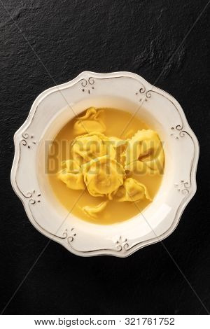 Italian Tortellini With Broth, Shot From Above On A Black Background With A Place For Text