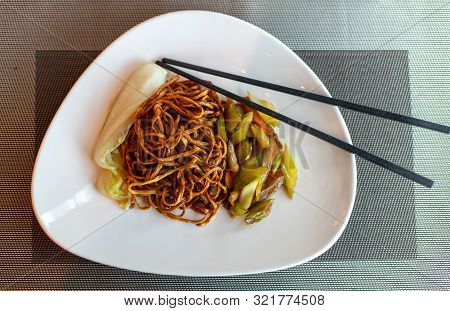Chinese Fried Noodles And Chopsticks. Side Dish Of Celery And Carrots. Chinese Cabbage. Brown Chines