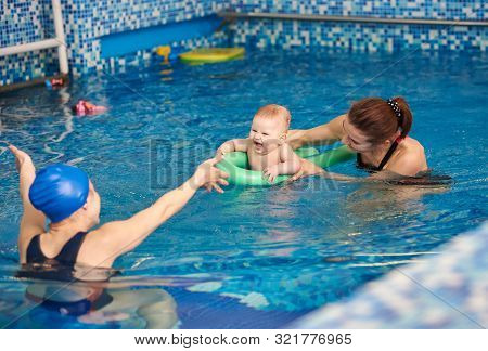Back View Of Happy Young Mother Stretching Out Her Arms To Little Son, Laughing Baby Having Fun Duri