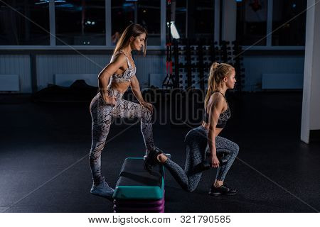 Female Fitness Instructor Conducts Personal Training. Young Attractive Woman Lunges On The Platform 