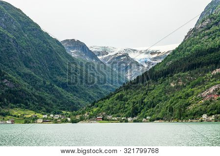 Folgefonna Glacier Cap In The Mountains With Lake And Village In The Foreground, Odda, Hardanger Reg