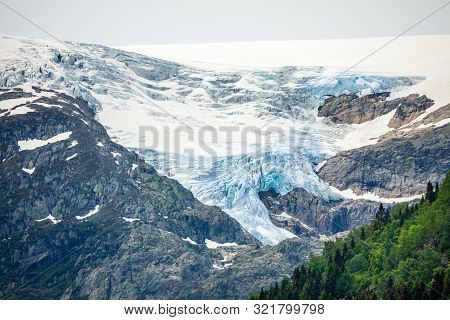 Folgefonna Glacier Cap In The Mountains With Forest In The Foreground, Odda, Hardanger Region,  Hord