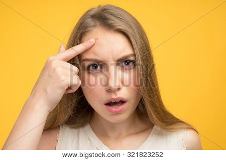 Portrait Of Sad Teen Gerl Touching Her Face And Looking For Acne On Yellow Background