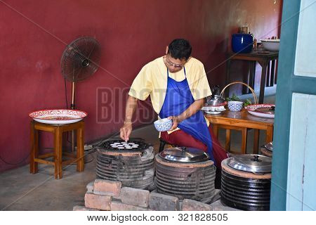 Kanchanaburi, Thailand, 09.09.2019: A Local Thai Man Is Preparing Thai Coconut Pancakes In A Traditi