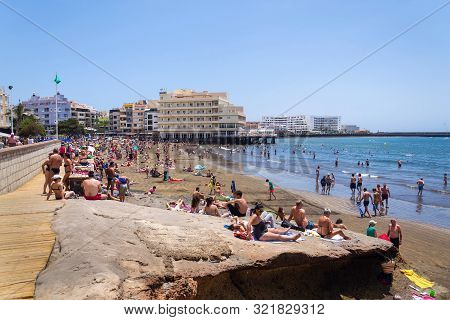 El Medano, Spain - July 7 2019: People Swimming And Sunbathing On Playa El Medano Beach On July 7, 2