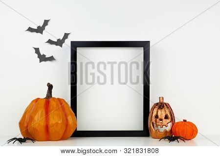 Mock Up Black Frame With Jack O Lantern And Pumpkin Decor On A Shelf Or Desk. Halloween Concept. Por