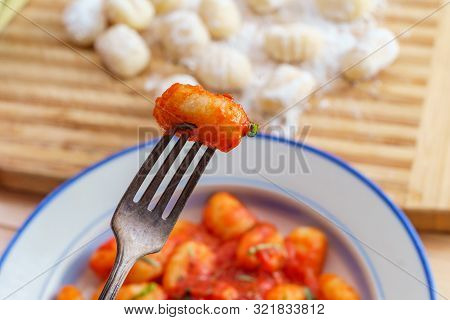 Italian Gnocchi In Red Marinara Tomato Sauce With Basil On Wooden Kitchen Table