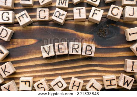 Word Verb Composed Of Wooden Cubes With Letters, Part Of Speech Concept Scattered Around The Cubes R