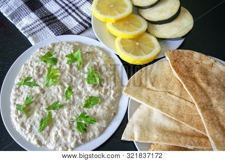 Famous Traditional Arabic Cuisine - Dip Baba Ganoush With Pita Bread And Fresh Lemon On Dark Wooden 