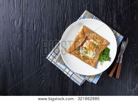 Breton Crepe, Savory Buckwheat Galettes Bretonnes With Fried Egg, Cheese, Ham Served On A White Plat
