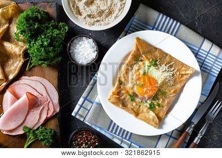 Breton Crepe, Savory Buckwheat Galettes Bretonnes With Fried Egg, Cheese, Ham On A White Plate On A 