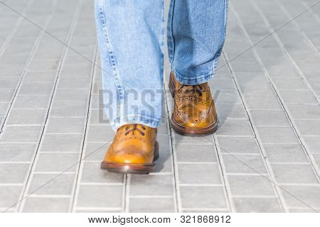 Close-up Of Male Legs In Leather Brown Oxford Semi Brogues Shoes. Photographed In Motion While Walki