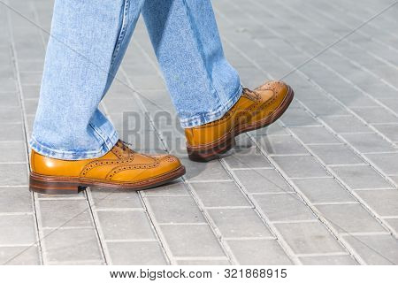 Close-up Of Male Legs Wearing Leather Brown Oxford Semi Brogues Shoes. Photographed In Motion. Horiz