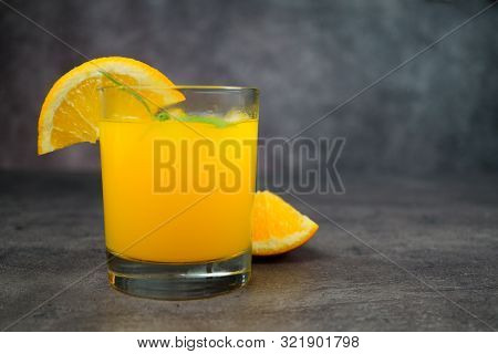 A Glass Of Fresh Orange Juice On Grey Background.