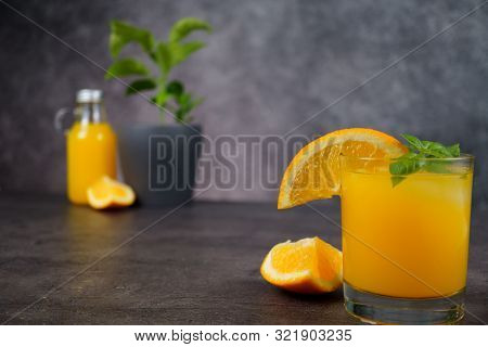 A Glass Of Fresh Orange Juice On Grey Background.