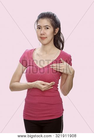 Asian Woman Wearing A Pink Hand Checking Lumps On Her Breast For Signs Of Brest Cancer On Bright Pin