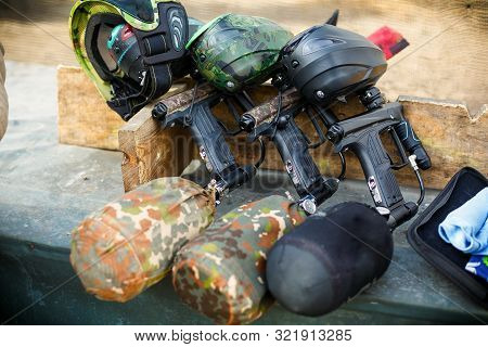 Three Paintball Markers With Air Balloons Stand In A Row On A Board