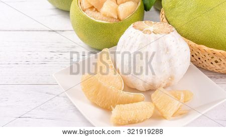 Fresh Peeled Pomelo, Pummelo, Grapefruit, Shaddock On Bright Wooden Table Background. Seasonal Fruit