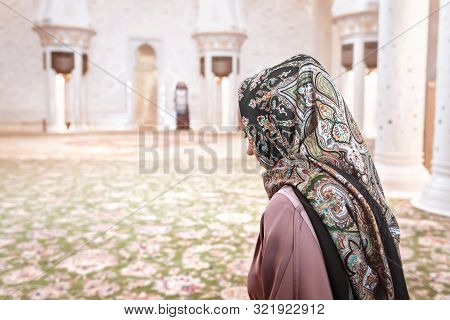 Woman In Muslim Prayer Room In Mosque. Young Lady Wearing Headscarf. Traditional Carpet And Arab Arc