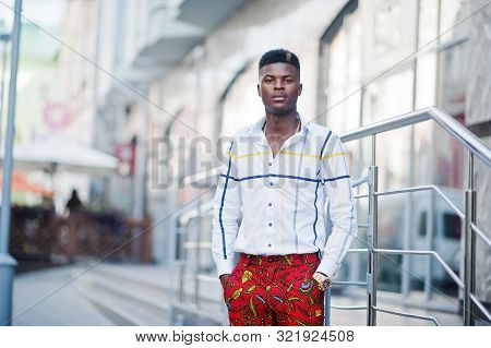 Portrait Of Handsome Stylish African American Model Man In Red Throusers And White Shirt.
