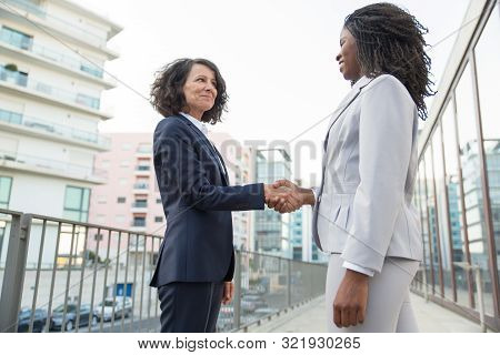 Happy Positive Female Business Colleagues Greeting Each Other Outside. Successful Business Women Sta