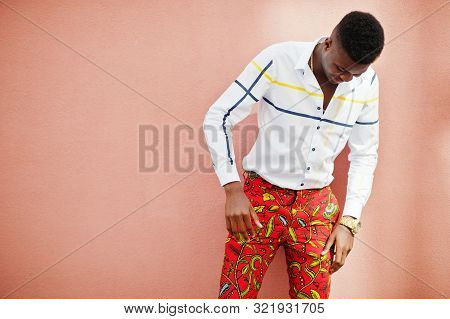 Portrait Of Handsome Stylish African American Model Man In Red Throusers And White Shirt Against Pin
