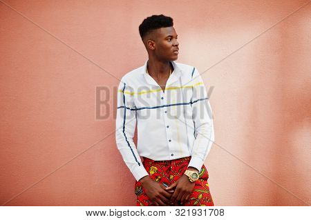 Portrait Of Handsome Stylish African American Model Man In Red Throusers And White Shirt Against Pin