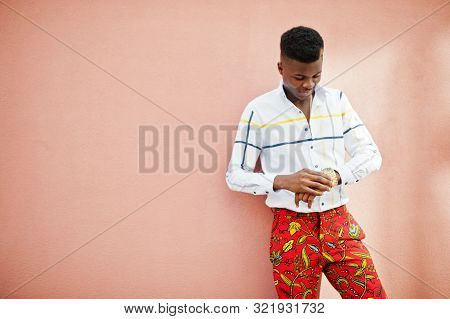 Portrait Of Handsome Stylish African American Model Man In Red Throusers And White Shirt Against Pin