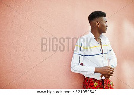 Portrait Of Handsome Stylish African American Model Man In Red Throusers And White Shirt Against Pin