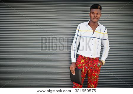 Portrait Of Handsome Stylish African American Model Man In Red Throusers And White Shirt With Laptop