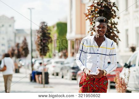 Portrait Of Handsome Stylish African American Model Man In Red Throusers And White Shirt With Cell P