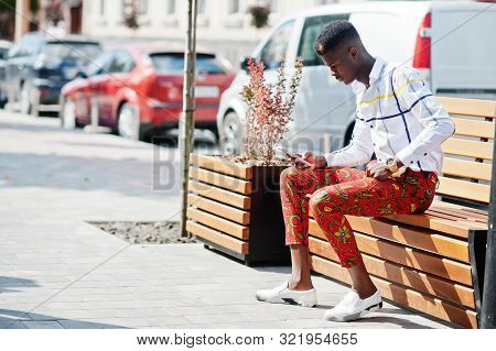 Portrait Of Handsome Stylish African American Model Man In Red Throusers And White Shirt With Cell P