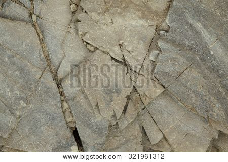 Gray Rough Rough Rock With Large Cracks.