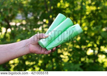 Man Holding Eco Plastic Garbage Bio Bags In Rolls Outdoors