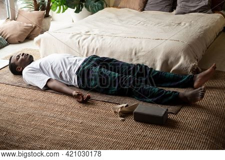Young Black Man Lying In Dead Body Exercise Or Corpse Pose With His Eyes Closed, Savasana Pose