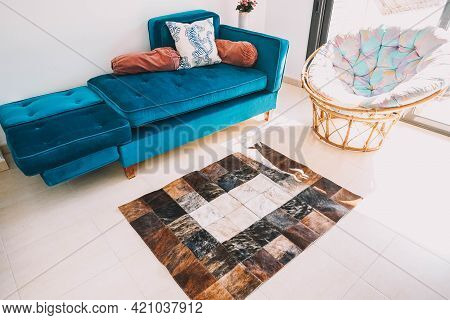 A Living Room Decorated With A Green Velvet Sofa And A Cowhide Rug