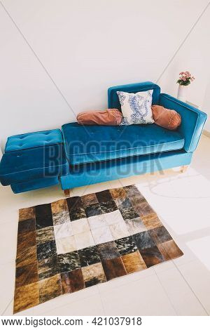 A Living Room Decorated With A Green Velvet Sofa And A Cowhide Rug